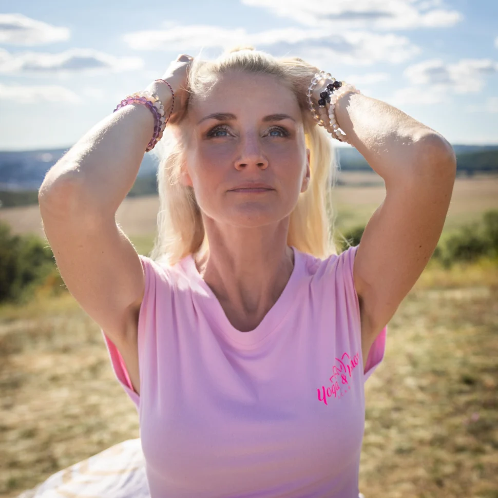 Certifikovaná lektorka Martina Bajerová z&nbsp;programu Facelift Yoga Experience předvádí uvolňující techniku péče o&nbsp;tvář v&nbsp;přírodě na&nbsp;slunné louce.